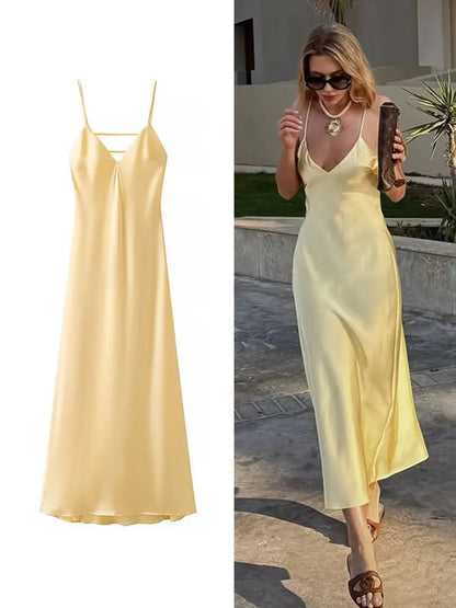 Yellow dress with a V-neck and thin straps, elegant, long, loose-fitting, sleeveless dress, 2025 style, for parties and special occasions.