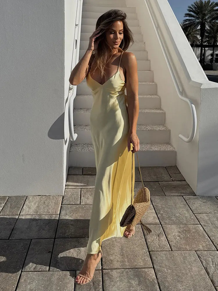 Yellow dress with a V-neck and thin straps, elegant, long, loose-fitting, sleeveless dress, 2025 style, for parties and special occasions.